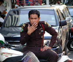 Policeman smoking on his motorcycle (Bangkok)